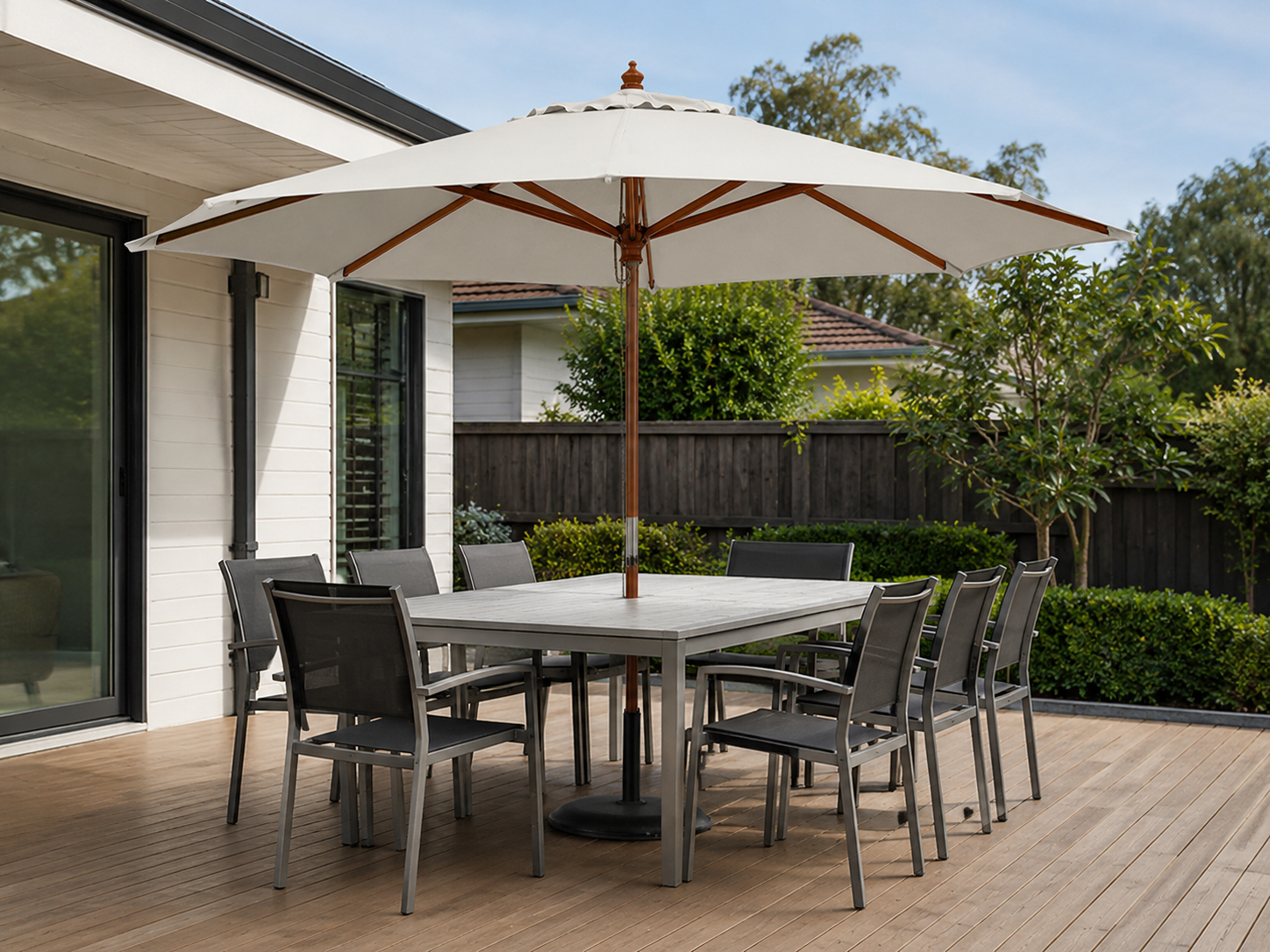 Backyard patio dining area with outdoor umbrella providing shade over a table and chairs